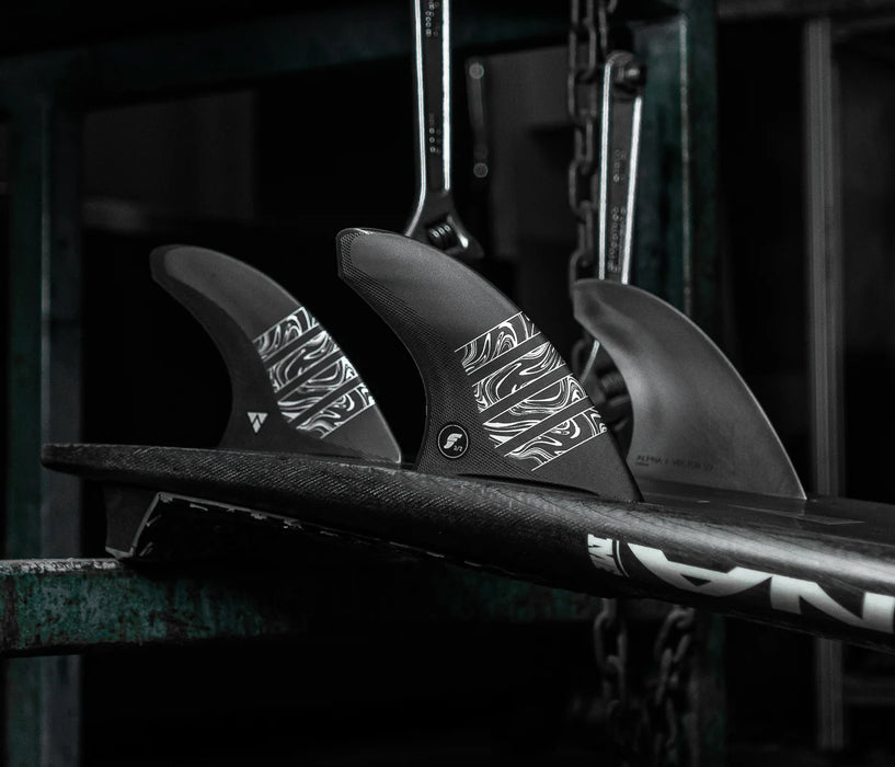 Futures Alpha Vector 3/2 size Large thruster fin set made of black recycled carbon with silver accents  installed in a surfboard