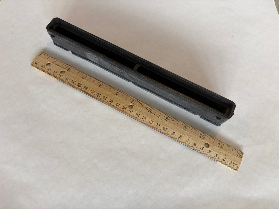 Bahne 10.5" surf channel or center fin box in black side angle view with a ruler to understand the length of this box.
