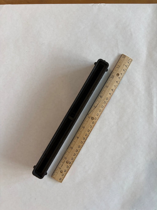 Bahne 10.5" surf channel or center fin box in black top down view with a ruler to understand the length of this box.