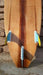 Hollow wood surfboard bottom with thruster Futures fins boxes visible