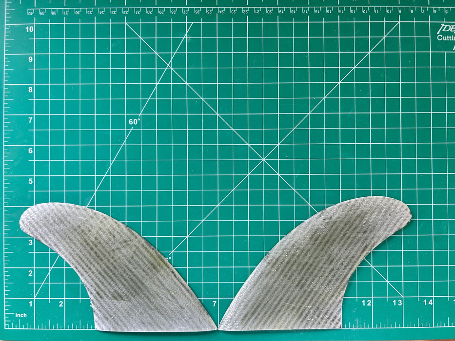 4 1/4" used translucent fiberglass with carbon weave glass on twin fins, side bites or half a quad set on a green grid 