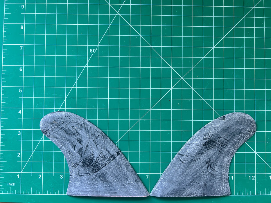 3 3/4" used Black opaque fiberglass glass on twin fins on a green grid