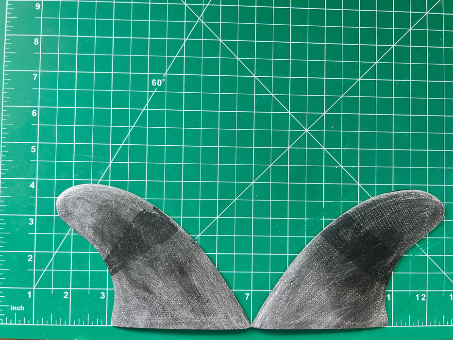 3 7/8" used black opaque fiberglass glass on twin fins, side bites or half a quad set on a green grid 