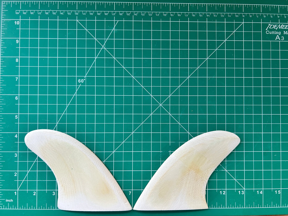 4 1/8" used white opaque fiberglass glass on twin fins or side bites on a green grid