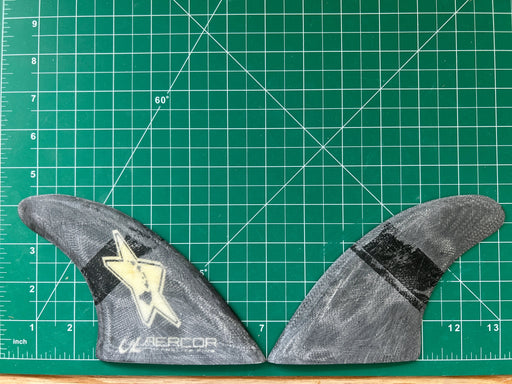 4 1/4" used Black opaque fiberglass glass on twin fins one of which AERCOR with State of Hawai'i islands inside a white star on a green grid 