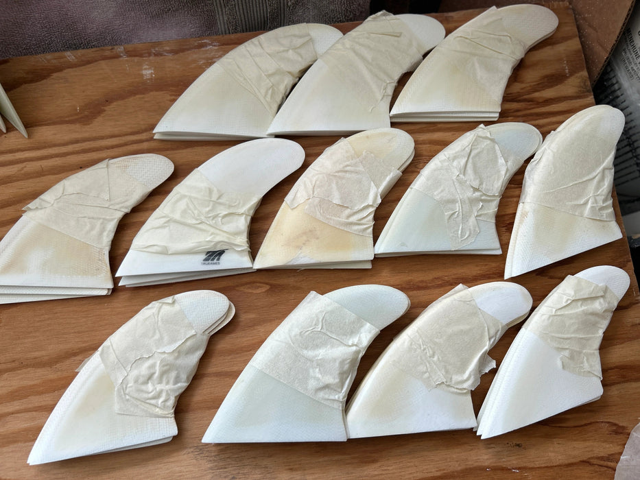 Many sets of white opaque thruster used glass on fins stacked one on top of each other