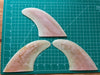 Three peach translucent used glass on fins stacked one on top of each other