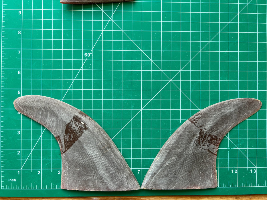 4 7/16" black opaque used fiberglass glass on twin fins, side bites or half a quad set on a green grid 