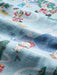 Super zoom in on a light blue fabric with Looney Tunes cartoon characters Bugs Bunny, Daffy Duck and others with a candy cane on a Christmas trees. 