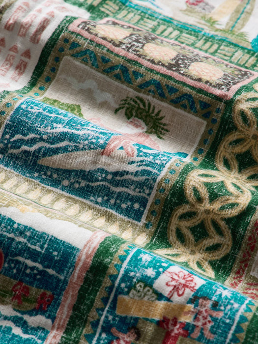 Super zoom in on a scene of Father Christmas wearing a fresh palm front open top hat called a papale niu piko'ole, on a surfboard riding a wave.