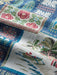 Super zoom in on a scene of a beached sea canoe with presents with an ama in front of a Hale with a Christmas decorated palm tree in navy theme.