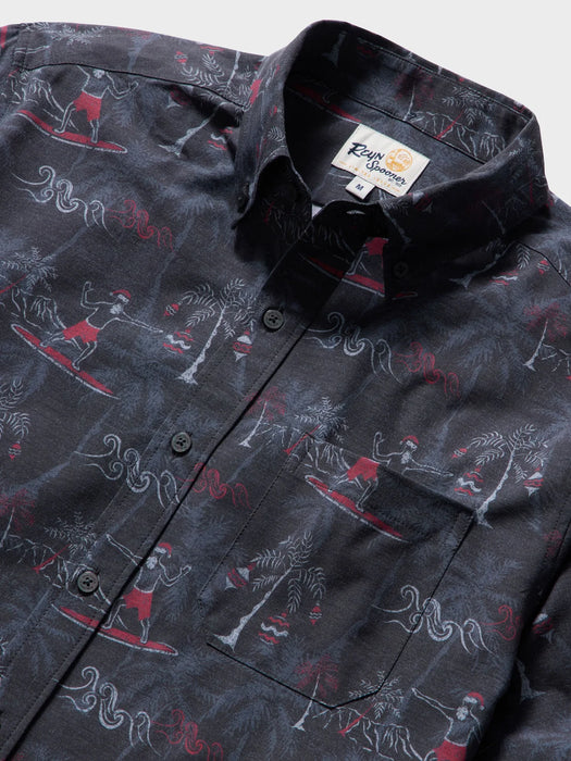 Close up of Surfin' Santa Performance Button Front Collared Short Sleeve Charcoal colored Aloha Shirt depicts Santa Surfing Waikiki with Diamondhead in the background.