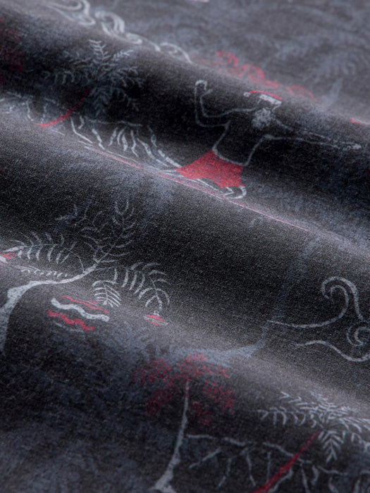 A close-up of dark charcoal gray fabric with a printed pattern of white line-art of Santa surfing with Diamondhead in the background.