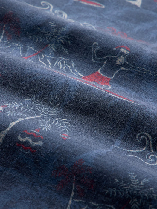 A close-up of navy colored fabric with a printed pattern of white line-art of Santa surfing with Diamondhead in the background.
