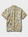 A short-sleeve button-up collared classic shirt back view with an all-over khaki fabric map print featuring Route 66 motifs, illustrated landmarks, and small colorful details.