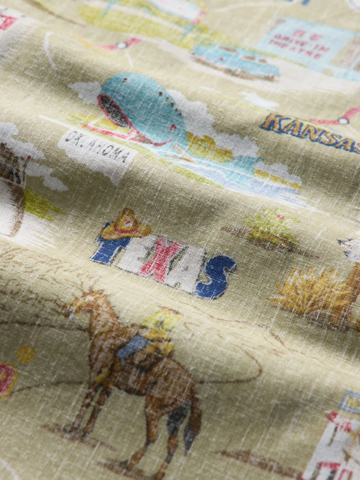 A close-up of a khaki fabric printed with a colorful themes about Route 66 with Kansas, Oklahoma and Texas shown in this super zoomed in image.