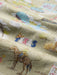 A close-up of a khaki fabric printed with a colorful themes about Route 66 with Kansas, Oklahoma and Texas shown in this super zoomed in image.