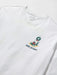 A close-up of a white long-sleeve t-shirt with a small graphic on the left chest showing a surfboard with wrapped presents and the text 'REYN SPOONER'.