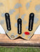 Close-up of the tail section of a short board surfboard with three of five Futures black fin boxes.