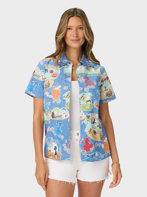 A woman modeling a light blue short-sleeve unbuttoned shirt celebrating It’s the Great Pumpkin, 1966 TV Special. Images of Charlie Brown, Snoopy, and the gang.