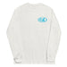 Ash long-sleeve crewneck shirt front view, with baby a blue and white graphic print of surfboards, palms and hut with the text 'KIMO'S SURF HUT' inside a double oval on the left chest.