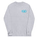 Grey long-sleeve crewneck shirt front view, with baby a blue and white graphic print of surfboards, palms and hut with the text 'KIMO'S SURF HUT' inside a double oval on the left chest.